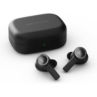 Een paar Bang & Olufsen Beoplay EX Black Anthracite draadloze oordopjes met siliconen dopjes zitten voor een bijpassend rechthoekig oplaaddoosje met een groen indicatielampje.