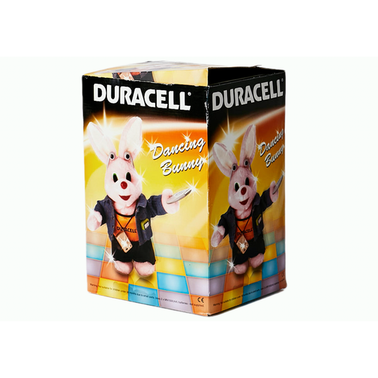 Duracell Dancing Bunny uit 1996 (New Rare Old Stock) doos toont de klassieke Duracell bunny mascotte in een zwart vest en zonnebril met drumstick, kleurrijk ontwerp en "Dancing Bunny" tekst-authentieke Duracell collectible.