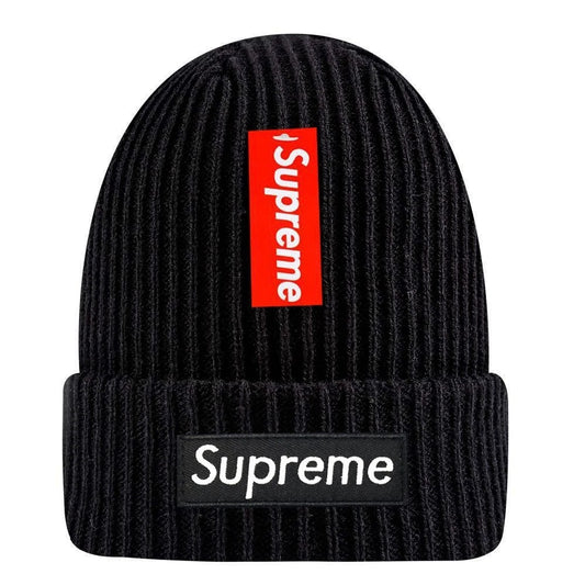 De Supreme New Era® Box Logo Beanie - Zwart is een zwarte gebreide muts met een rood verticaal Supreme label en een zwarte horizontale Supreme patch op de vouw, waardoor stijl en exclusiviteit samenkomen in dit limited edition accessoire.