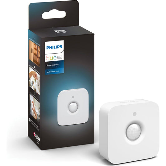 Een kleine, witte, vierkante bewegingssensor van Philips Hue wordt getoond naast de verpakking, waarop de productnaam en het merk staan. De draadloze sensor heeft een centrale ronde sensor voor slimme lampen.