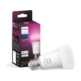 De Philips Hue standaardlamp - RGB en Wit (1-pak, E27) van Philips wordt naast zijn doos getoond, met Bluetooth en stemassistent-compatibiliteit, met zowel witte als gekleurde verlichtingsopties.