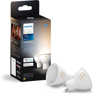 Een doos met Philips Hue Spot warm-tot koelwit licht (2 pack) van Philips wordt getoond, met twee GU10-fitting lampen. Op de verpakking staat 400 lumen helderheid en ondersteuning voor Alexa, Google Home en Zigbee connectiviteit.