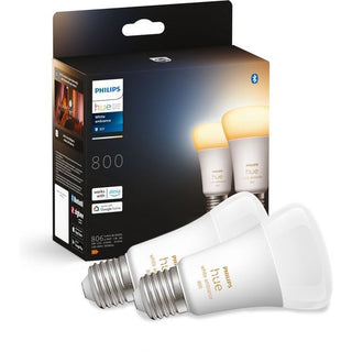 Twee Philips Hue Slimme Lichtbron E27 Duopack lampen van Philips staan voor hun zwarte doos, waarop compatibiliteit met slimme verlichtingssystemen zoals Alexa en Google Assistant wordt weergegeven.