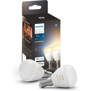 Twee Philips Hue kogellampen (2-pak) zitten voor hun doos met het Philips-logo, die is voorzien van een slim verlichtingssysteem dat compatibel is met Alexa en Google Assistant, plus een afbeelding van een warm tot koel verlichte kamer.