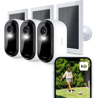 Drie ARLO Essential FHD Outdoor Beveiligingscamera's + Zonnepanelen (3-Pack) tonen live beelden van een vrouw die in de tuin voetbalt, zichtbaar op een smartphone. Ideaal als draadloze Wi-Fi beveiligingscamera voor buiten.