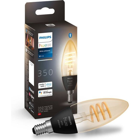 De Philips Hue filamentkaars (1-pack, E14) van Philips biedt warm- tot koelwit licht en is hier te zien naast de verpakking met info over Alexa- & Google Assistant-compatibiliteit.