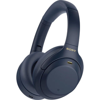 De Sony WH-1000XM4 - Draadloze over-ear met Noise Cancelling in blauw heeft zachte oorkussens en hoofdband, het Sony-logo in goud op de zijkant en een zichtbare oplaadpoort op de linker oorschelp.