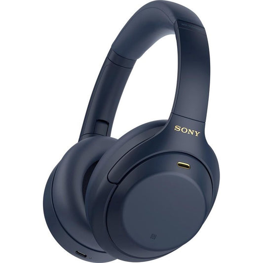 De Sony WH-1000XM4 - Draadloze over-ear met Noise Cancelling in blauw heeft zachte oorkussens en hoofdband, het Sony-logo in goud op de zijkant en een zichtbare oplaadpoort op de linker oorschelp.