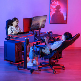 Twee mensen gebruiken DealFixers Pro-Series Mobiele Ergonomische Gaming Bureaus met computers in een blauw en roze verlichte kamer; de een zit rechtop, de ander ligt achterover in een ergonomische gamingstoel, met een gloeiende neonposter achter hen.